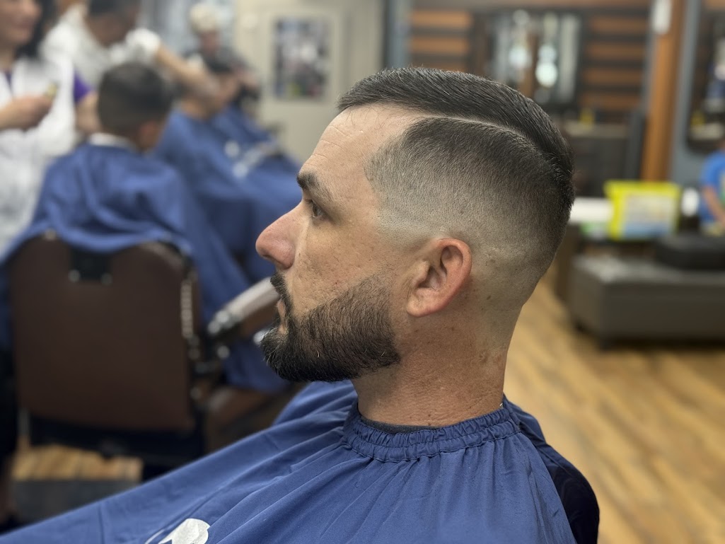 High skin fade with hard part and beard sculpt by Twins Barber Shop
